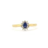 A hallmarked 9ct yellow gold cluster ring set with an oval cut sapphire surrounded by diamonds, (