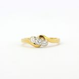 An 18ct yellow gold ring set with three rub over brilliant cut diamonds, (N).