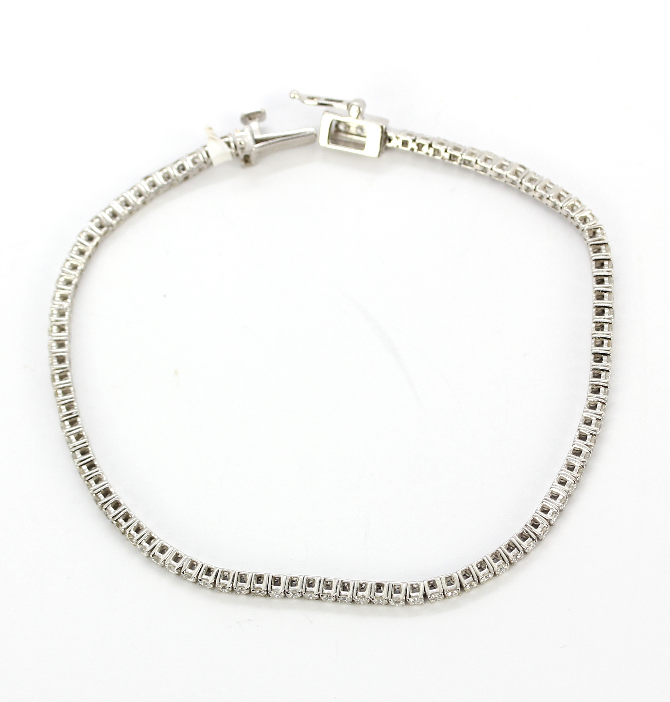 An 18ct white gold tennis bracelet set with brilliant cut diamonds, approx. 2.25gr total, L. 19cm. - Image 3 of 4