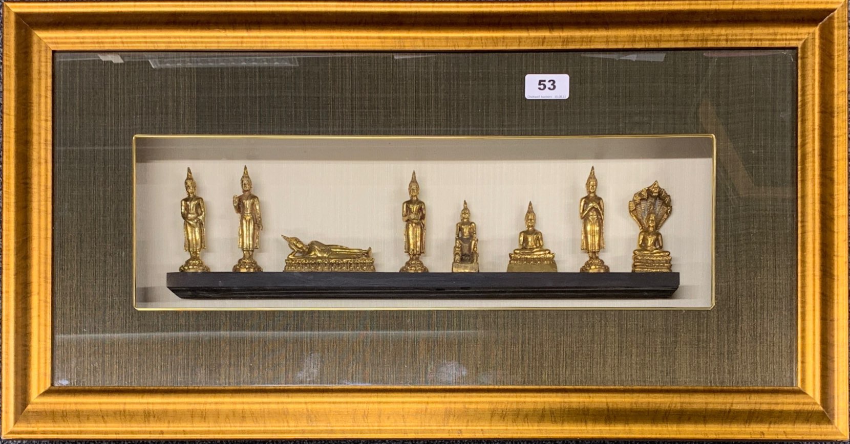 A cased set of Thai Buddhist figures, frame size 74 x 39cm.