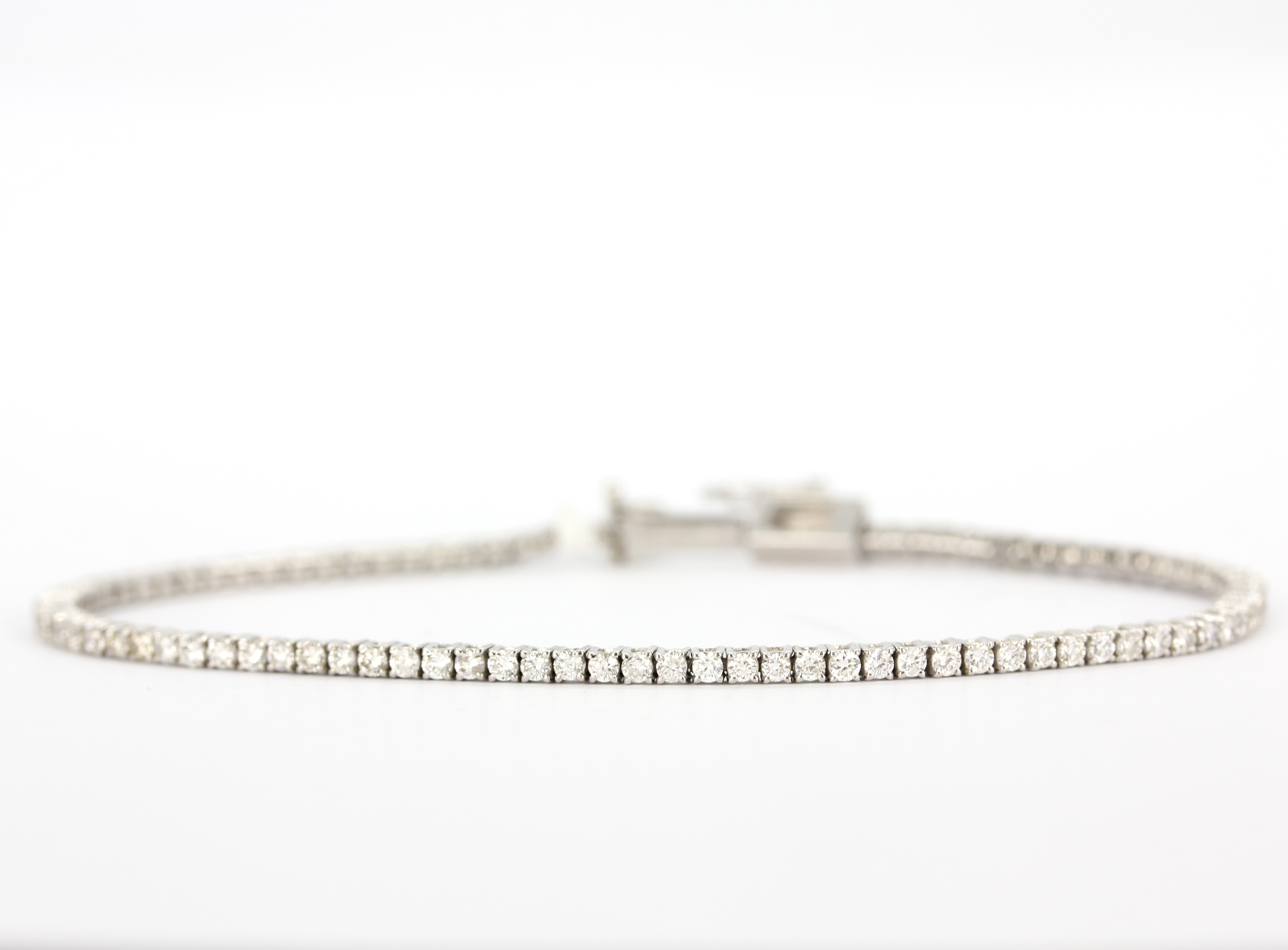 An 18ct white gold tennis bracelet set with brilliant cut diamonds, approx. 2.25gr total, L. 19cm.