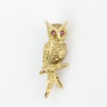 An antique 9ct yellow gold owl shaped brooch, circa 1958, with ruby set eyes, L. 4.2cm.