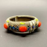 A Tibetan enamelled silver on copper heavy bangle, W. 2.2cm, internal Dia. 6cm.