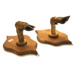 A pair of oak shield and dear hoof wall mounted snooker cue rests, H. 36cm.