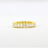 A 925 silver gilt eternity ring set with princess cut cubic zirconias, (M).