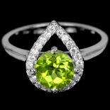 A 925 silver ring set with a round cut peridot and white stones, (O).