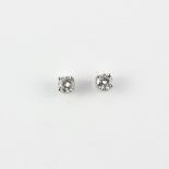 A pair of white metal (tested minimum 9ct gold) solitaire stud earrings each set with a brilliant