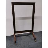 An antique mahogany and glass fire screen with brass trim and feet, H. 101cm.