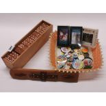 A handmade box containing a double set of teak dominos, with badges etc.