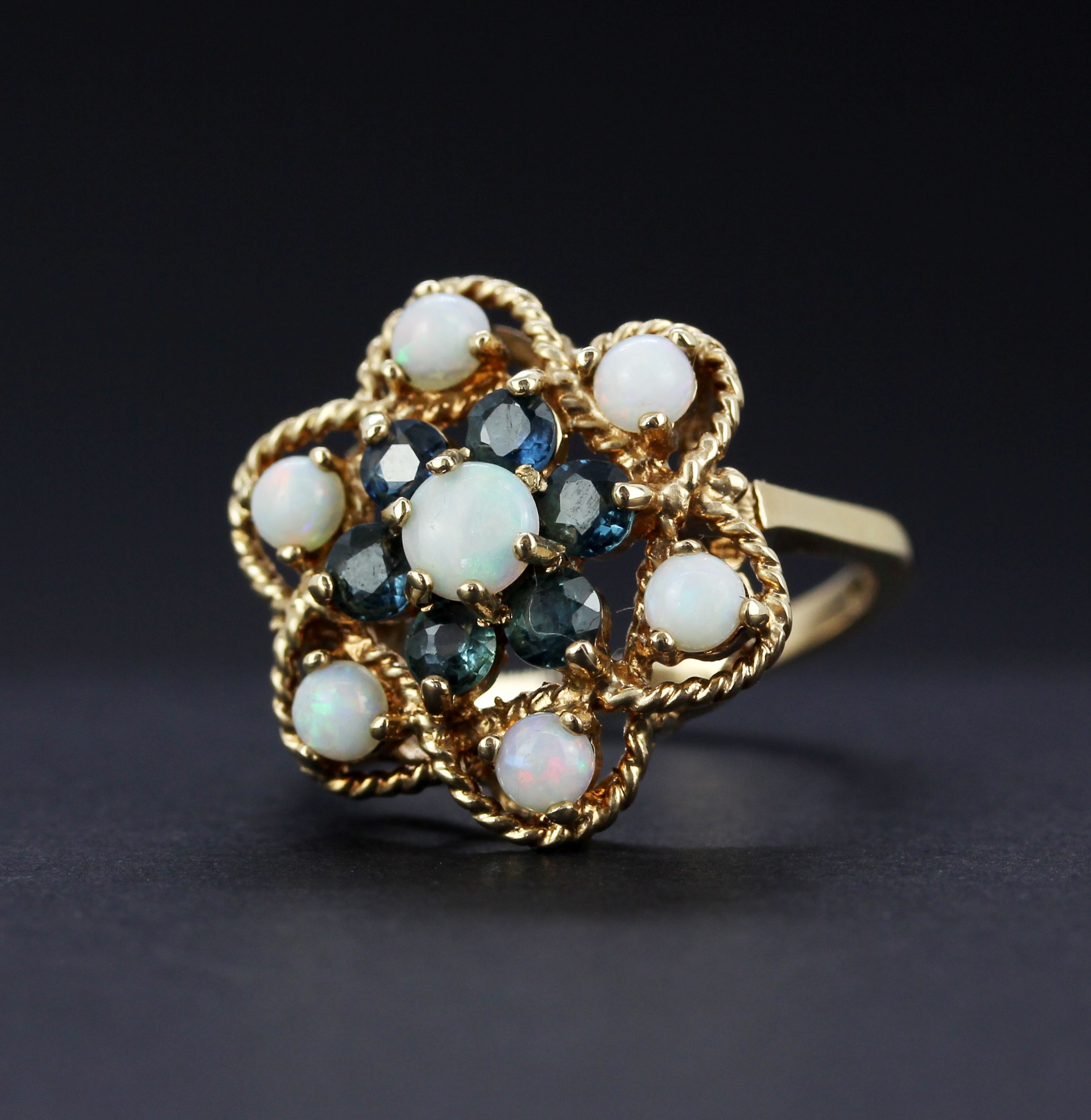 A large hallmarked (worn hallmark) 9ct yellow gold ring set with round cabochon cut opals and