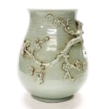 An unusual Chinese hand potted relief decorated celadon glazed vase, H. 23cm.