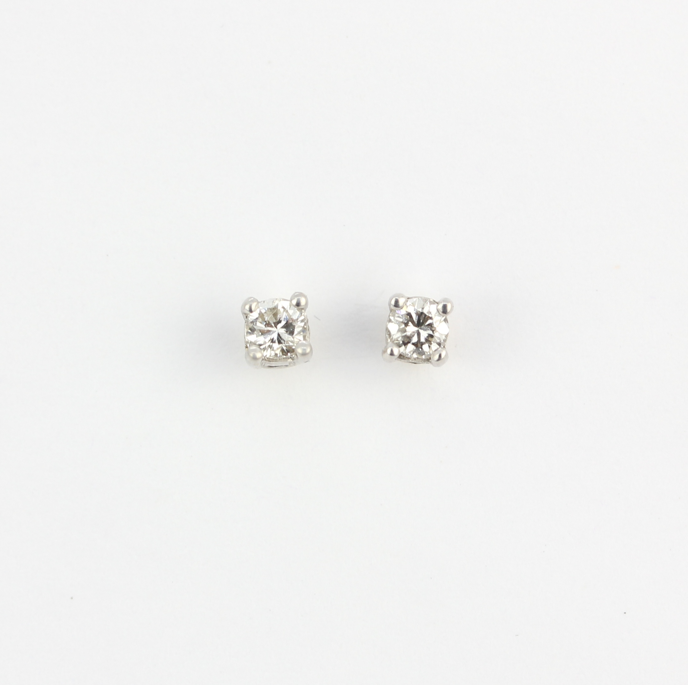 A pair of 9ct yellow and white gold solitaire stud earrings each set with a brilliant cut diamond,