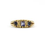 A hallmarked 9ct yellow gold ring set with oval cut tanzanites, (O.5).