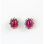A pair of 925 silver cluster earrings set with an oval cabochon cut ruby surrounded by cubic