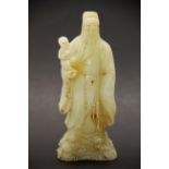 A Chinese carved pale celadon jade figure of a lucky God holding a child while standing on clouds,