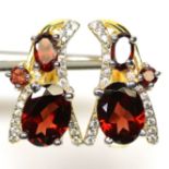 A pair of gold on 925 silver earrings set with oval cut garnets and white stones, L. 1.6cm.