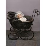 A Victorian style doll's pram, H. 65cm, with a porcelain head sleeping baby doll.