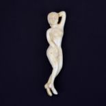 A carved bone figure of a young nude female, L. 13cm.