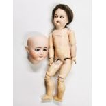 An Armond Marseilles 390 doll with porcelain head and articulated composition body, H. 35cm,