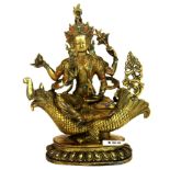 A Tibetan gilt bronze figure of a Tara seated on a dragon fish, H. 27cm.