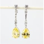 A pair of 925 silver drop earrings each set with a large pear cut yellow cubic zirconia and round