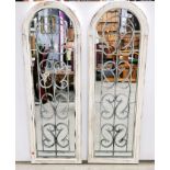 A pair of arched wood and wrought iron mirrors, H. 123cm.