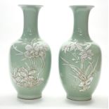 A pair of Chinese celadon glazed and white slip decorated porcelain vases, H. 28cm. Reign mark to