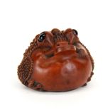 A carved fruitwood Netsuke of Chan the lucky toad with obsidian eyes, Dia. 5cm, H. 4cm.