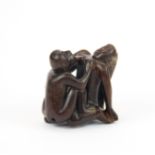 An erotic carved fruitwood Netsuke with inset mother of pearl signature panel, H. 4.5cm.