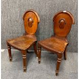 A pair of Victorian mahogany hall chairs.