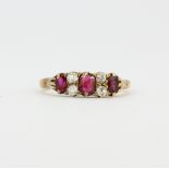 An 18ct yellow gold ring set oval cut rubies and rose cut diamonds, (K).