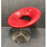 An upholstered swivel chair with chrome base.