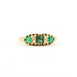 A hallmarked 18ct yellow gold ring set with fancy cut emeralds and diamonds, (K).