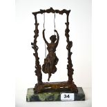 An Art Nouveau style bronze and marble figure of a girl on a swing, H. 27cm.