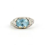 An 18ct white gold ring set with an oval cut aquamarine and brilliant cut diamonds, (J.5).