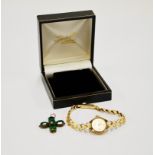 A ladies' 9ct gold Accurist wristwatch with a yellow metal stone set cross.