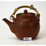 A mid 20th century Chinese terracotta teapot with bamboo handle, H. 14cm.