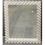 A large ornate silvered framed mirror, frame size 81 x 110cm.