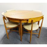 A 1970's G Plan extending circular dining table and four original chairs.