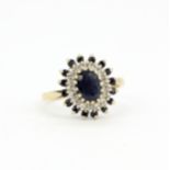 A hallmarked 9ct yellow gold cluster ring set with sapphires and cubic zirconias, (L).