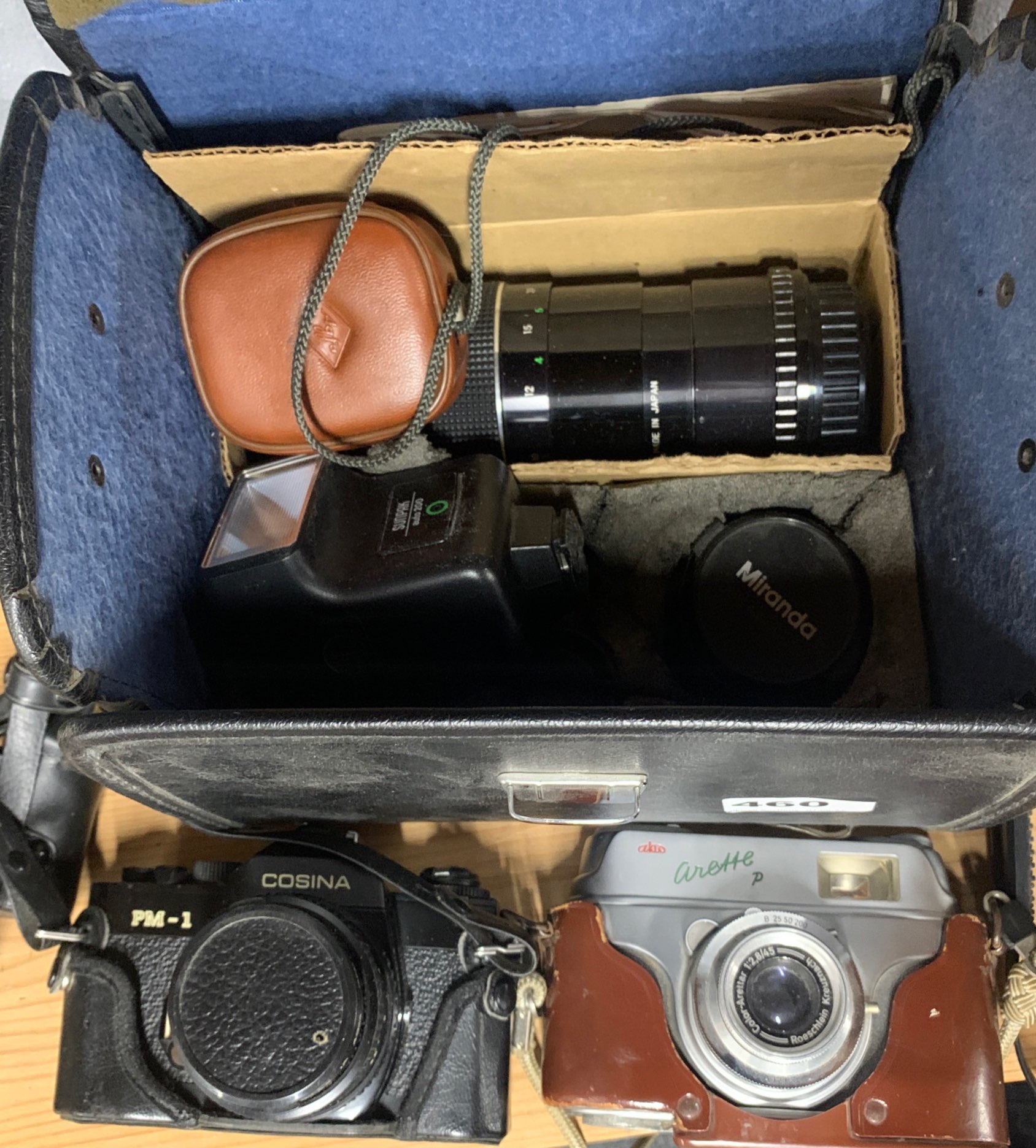 A Cosina single lens reflex camera with case and an Akio Arette P camera.