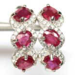 A pair of 925 silver earrings set with three oval cut rubies and white stones, L. 1.8cm.