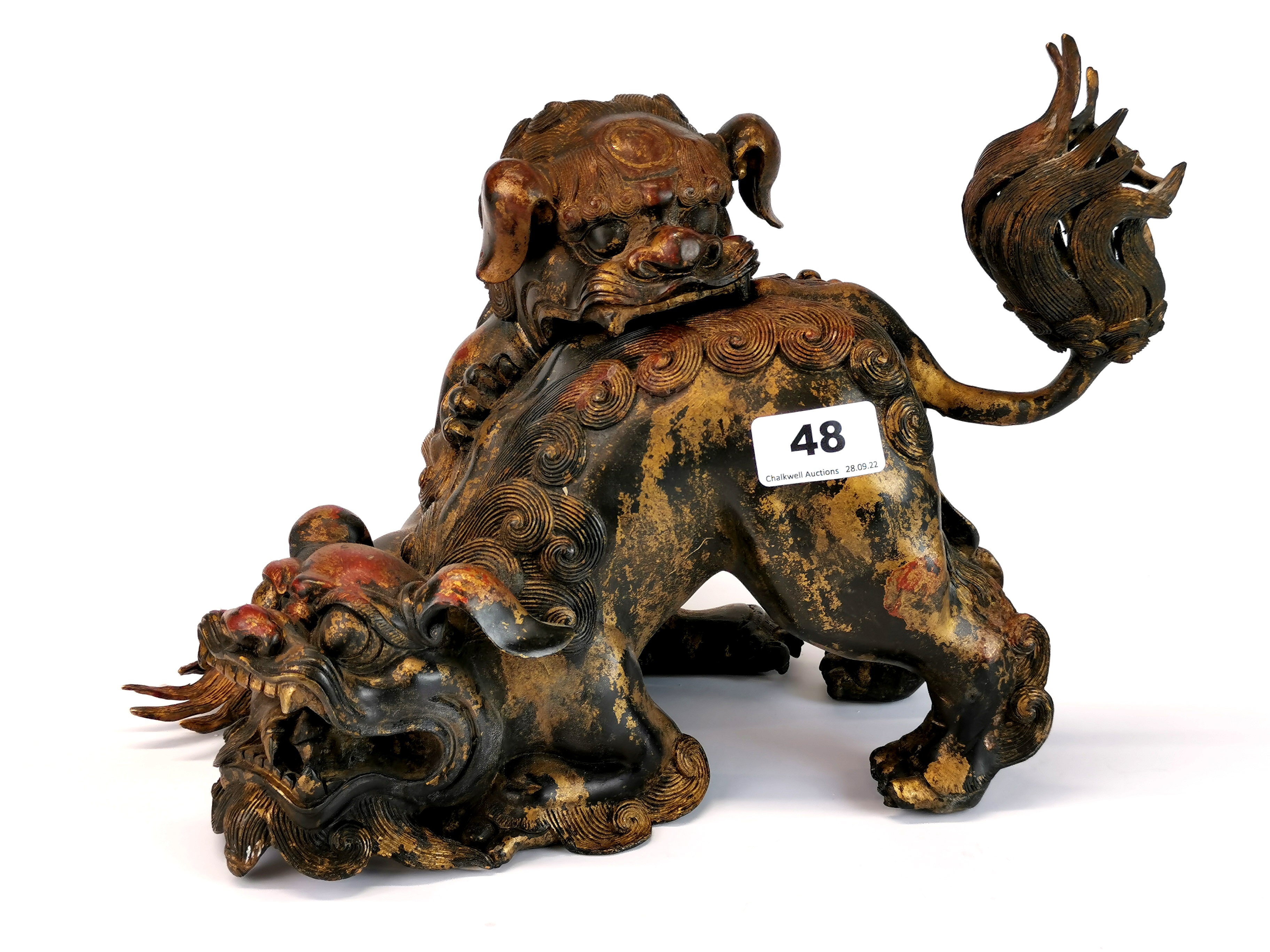 An unusual Chinese bronze model of two liondogs playing, one with removeable head, H. 21cm.