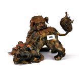 An unusual Chinese bronze model of two liondogs playing, one with removeable head, H. 21cm.