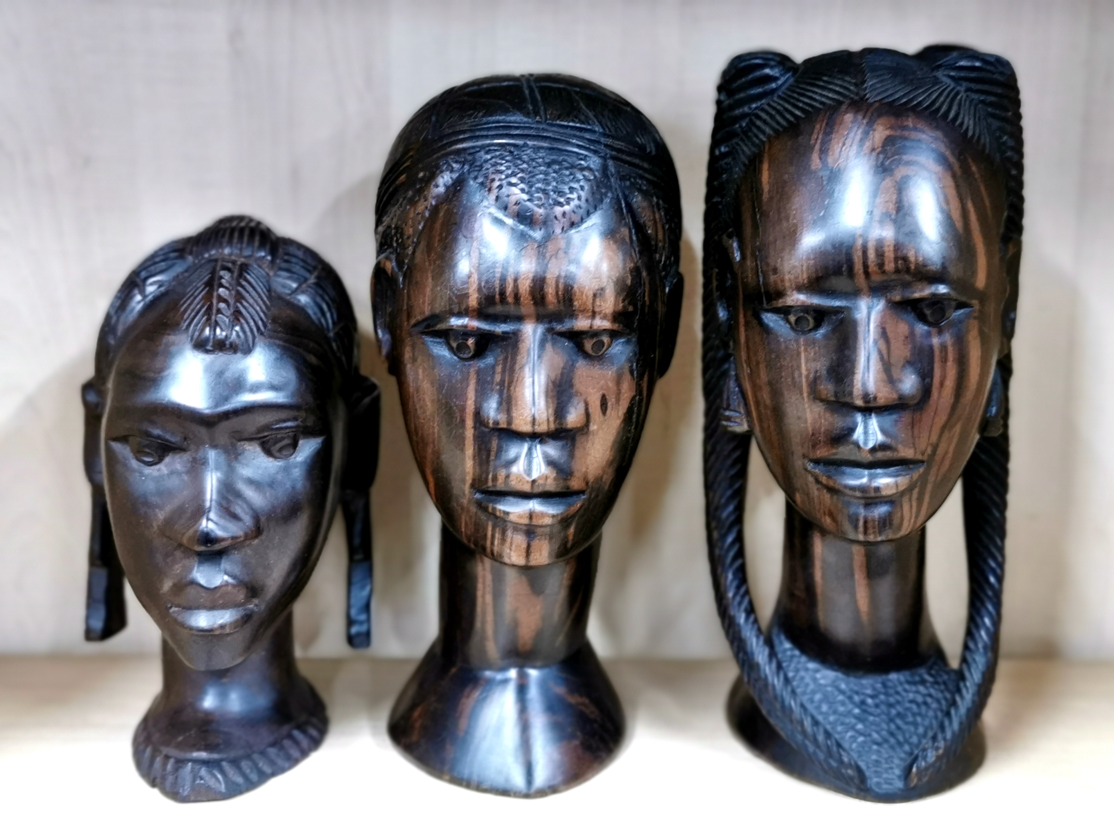 A group of three African carved figured ebony busts, largest H. 37cm.