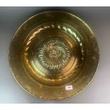 A large 18th century German hammered brass alms dish, Dia. 54cm. Prov. Estate of the late Dr.