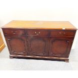 A mahogany veneered three drawer sideboard, W. 137cm, H. 79cm.