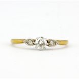 An 18ct yellow and white gold solitaire ring set with a brilliant cut diamond and diamond set