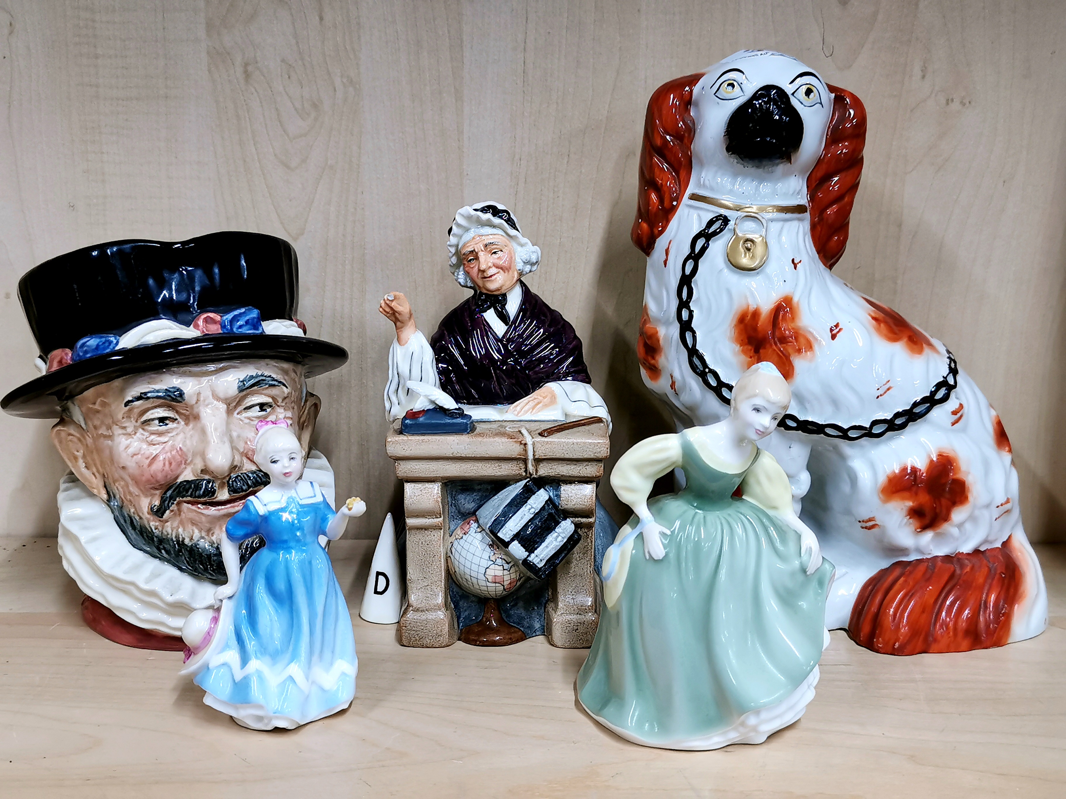 A Staffordshire dog figure with four Royal Doulton items.