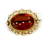 A yellow metal (tested minimum 9ct gold) brooch set with a large oval cut citrine and seed pearls,